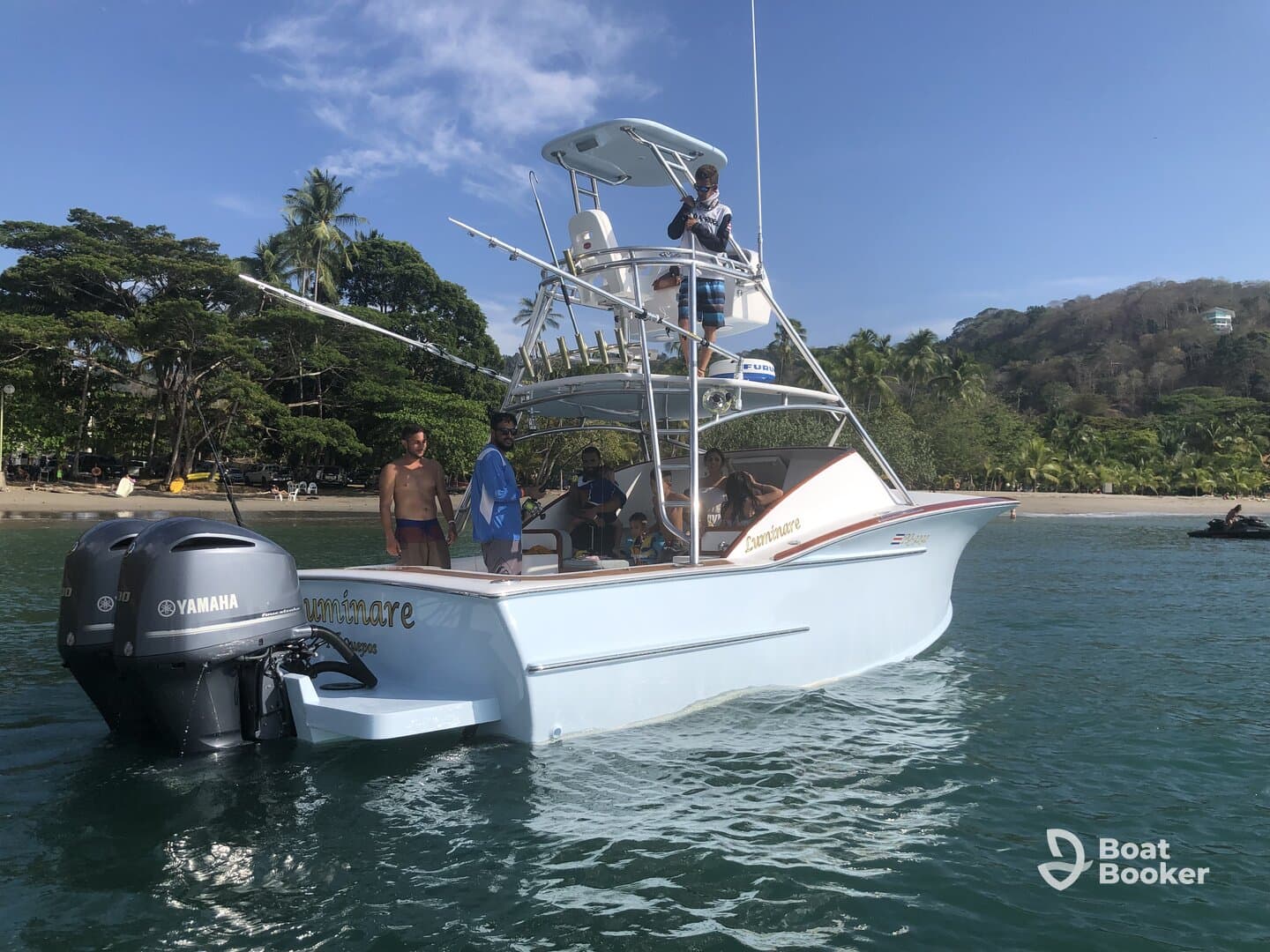 A lively group aboard a fishing boat, enjoying a day on the water with a scenic beach backdrop — perfect for fishing adventures and ocean exploration.