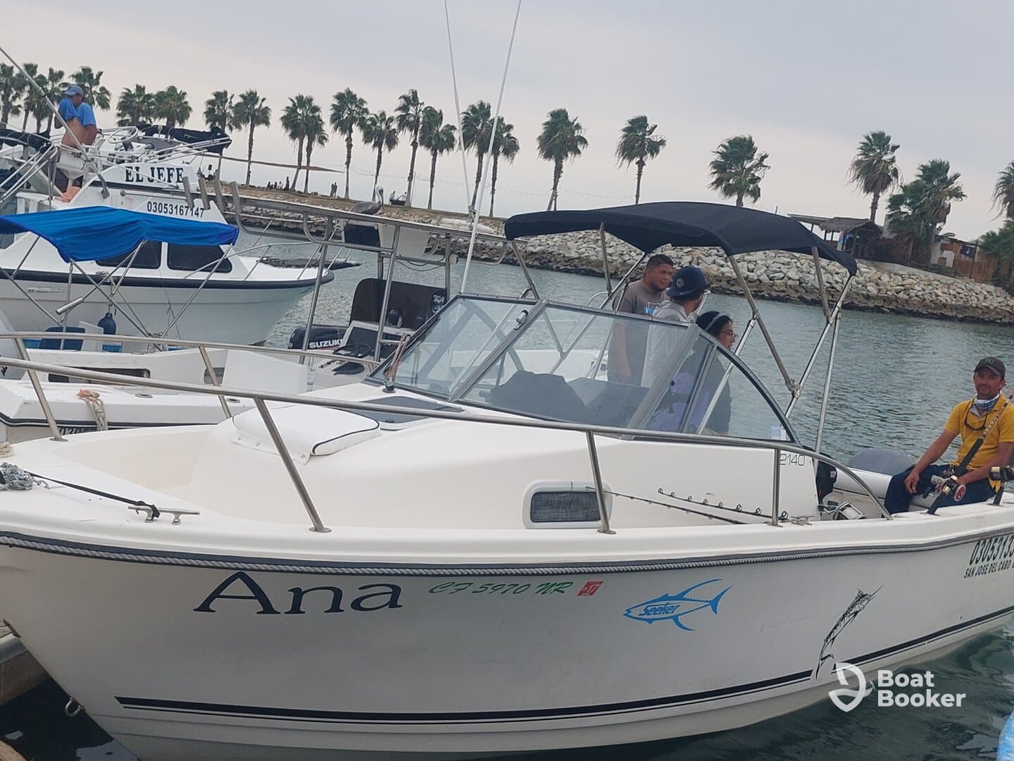 A group of people gathers on the boat named 'Ana' at the dock, ready for a fishing adventure. The vibrant atmosphere captures the excitement of a day on the water.