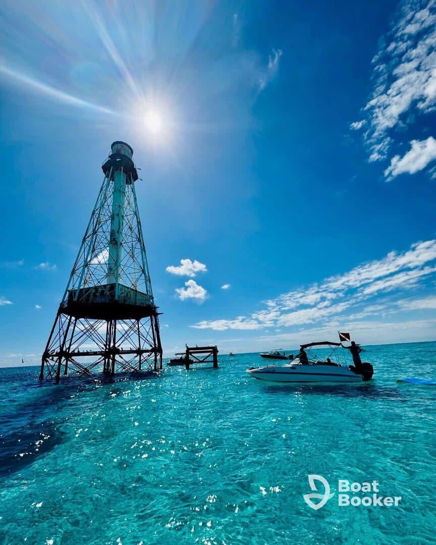 A stunning view of a lighthouse standing tall over crystal-clear turquoise waters, with boats nearby, capturing the essence of a perfect day on the water.
