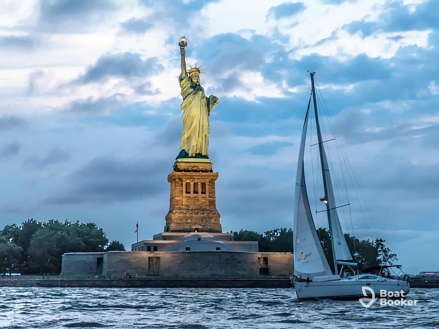 A picturesque view of a sailboat gliding past the iconic Statue of Liberty at sunset, showcasing a perfect blend of maritime adventure and historical landmarks.