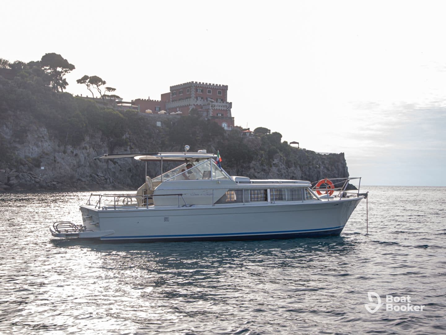 A beautiful yacht glides through calm waters, showcasing its elegant design against a scenic coastal backdrop.
