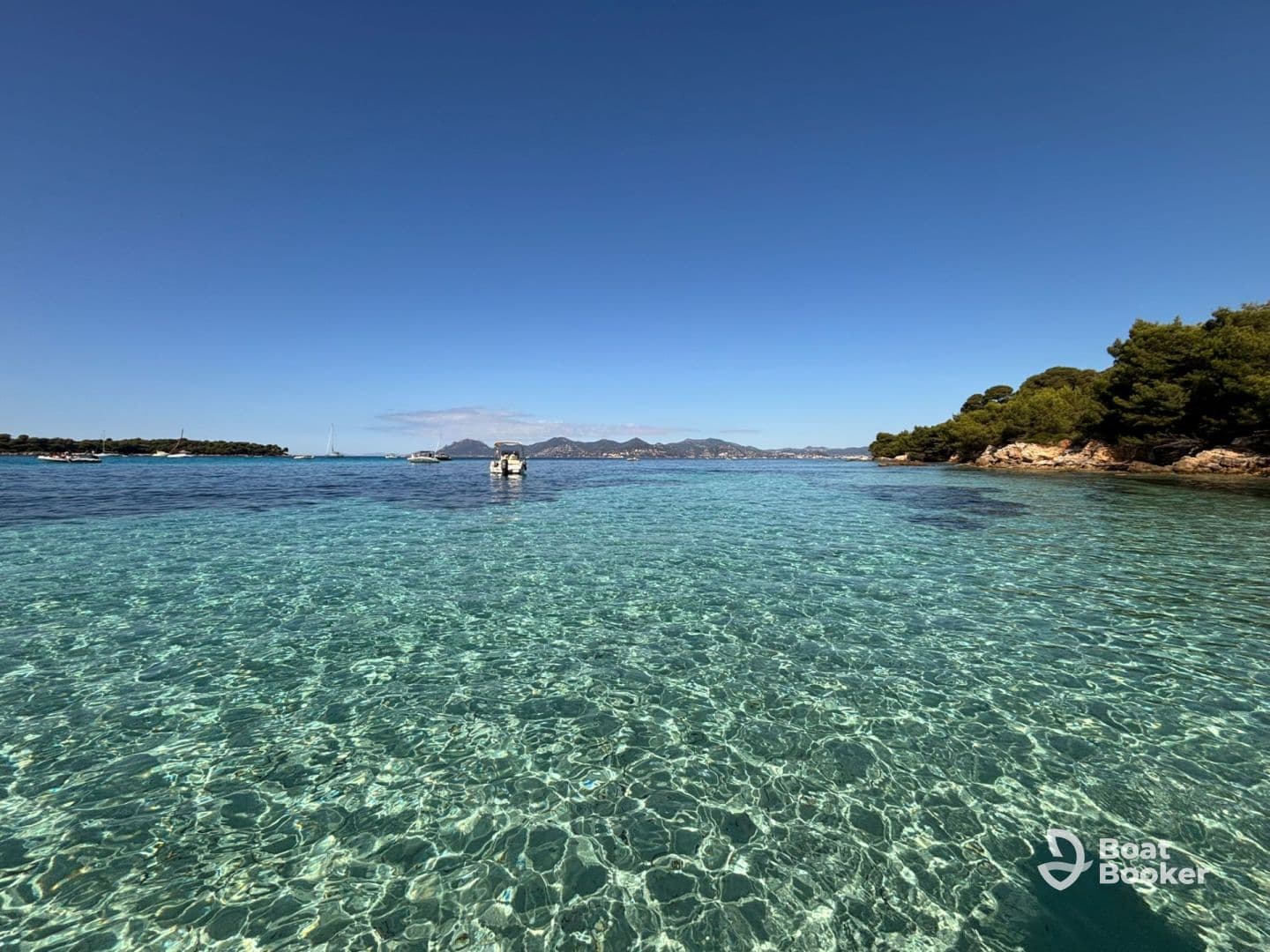 A stunning view of crystal-clear turquoise waters and a picturesque coastline, perfect for exploring the beauty of nature on a boating adventure.