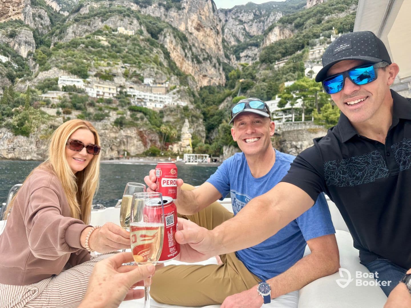 A cheerful group toasts with drinks on a boat, surrounded by stunning coastal scenery — perfect for memorable celebrations on the water.
