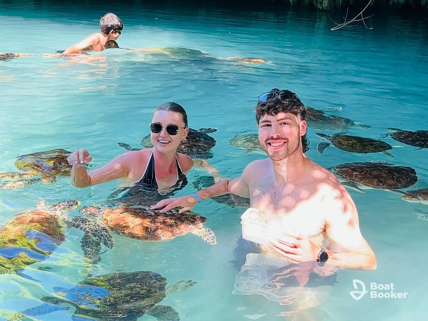 A joyful encounter as a couple interacts with sea turtles while swimming in crystal-clear waters — a memorable wildlife experience in a tropical paradise.