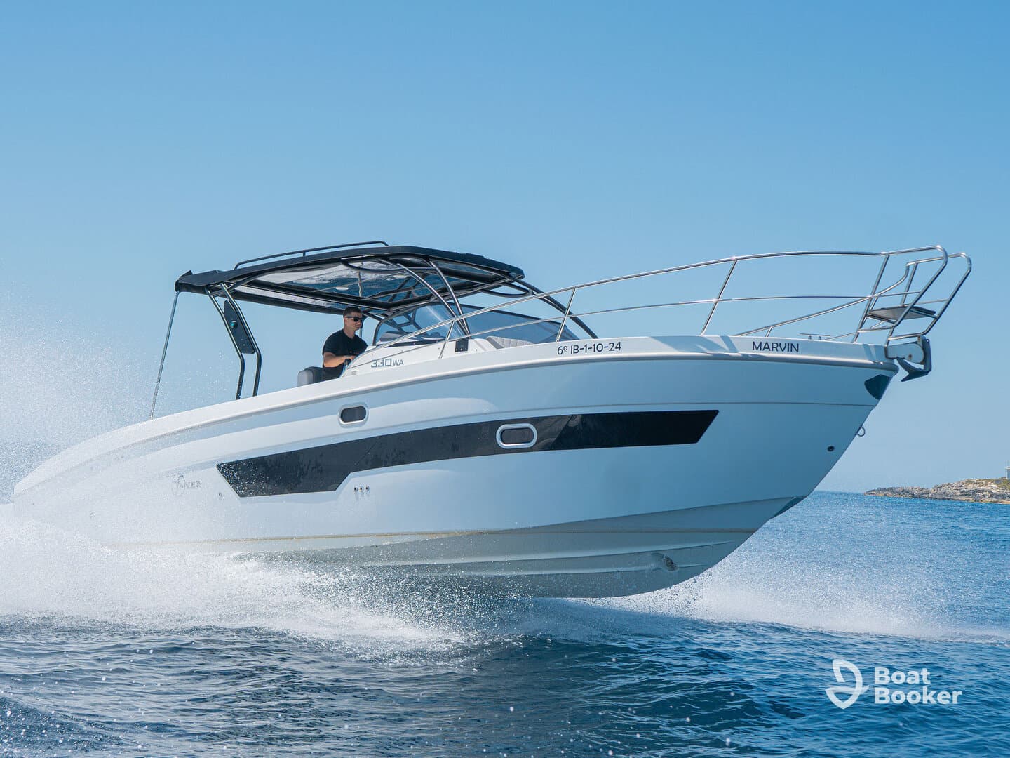 A sleek speedboat cuts through the water with a captain at the helm, showcasing its dynamic design and performance on the open sea.
