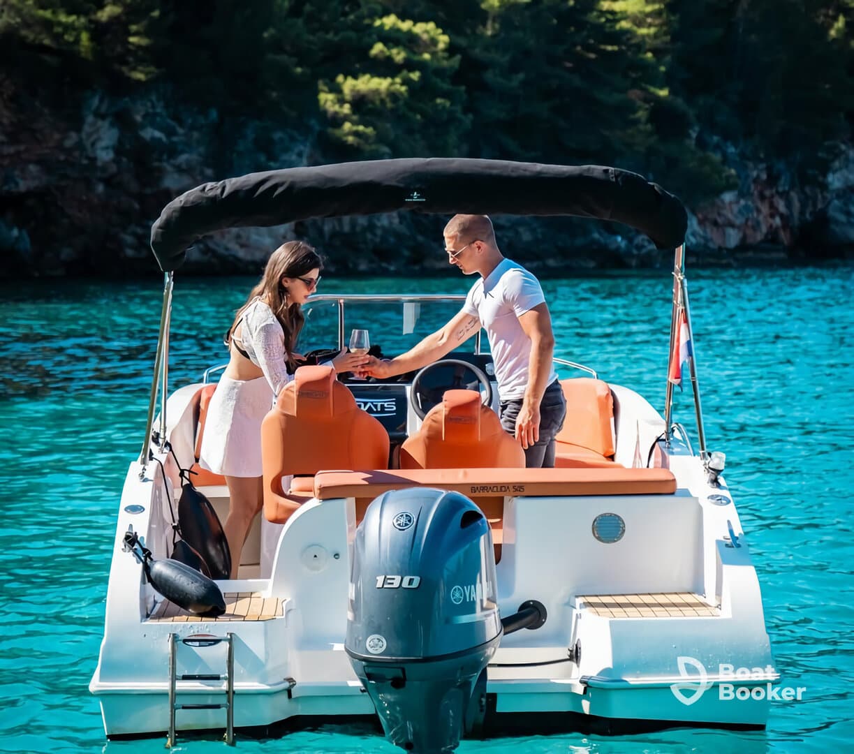 A couple enjoys a toast on their boat amidst stunning turquoise waters, perfect for romantic getaways and celebrations on the sea.