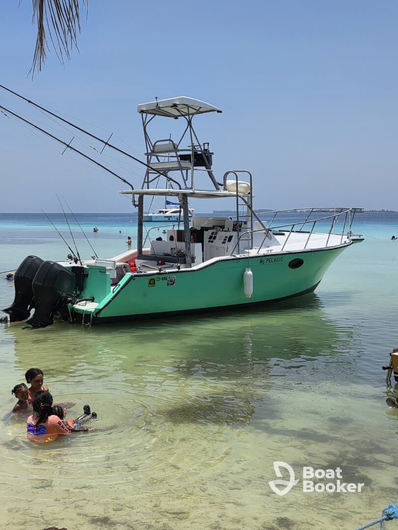 A family enjoys a fun day at the beach, splashing in the shallow water near a fishing boat — perfect for a memorable day on the water.