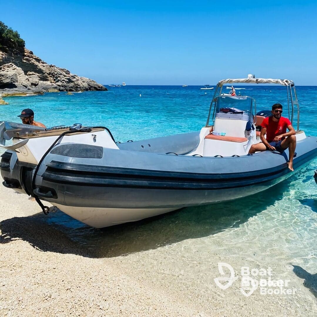 Two individuals relax on a boat at a picturesque beach, showcasing a perfect day on the water under the sun.