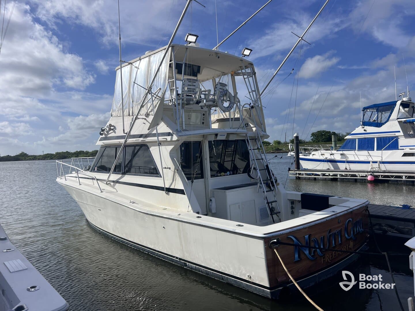 A striking view of a yacht docked at the marina, showcasing its sleek design and spacious layout, perfect for fishing or leisure trips.