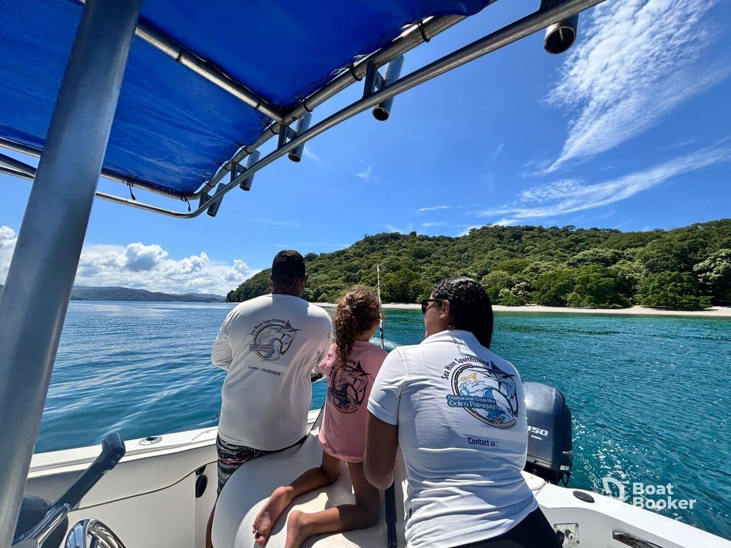 A family enjoys a fishing trip on a boat, taking in the beautiful scenery of lush green hills and clear waters — a perfect day for adventure on the water.