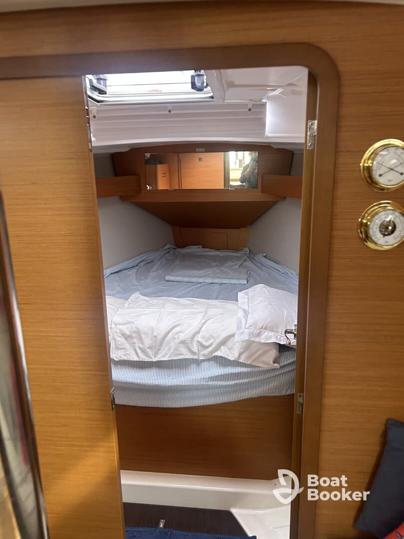 A cozy cabin interior featuring a comfortable bed and wooden finishes, perfect for relaxing on a boat getaway.
