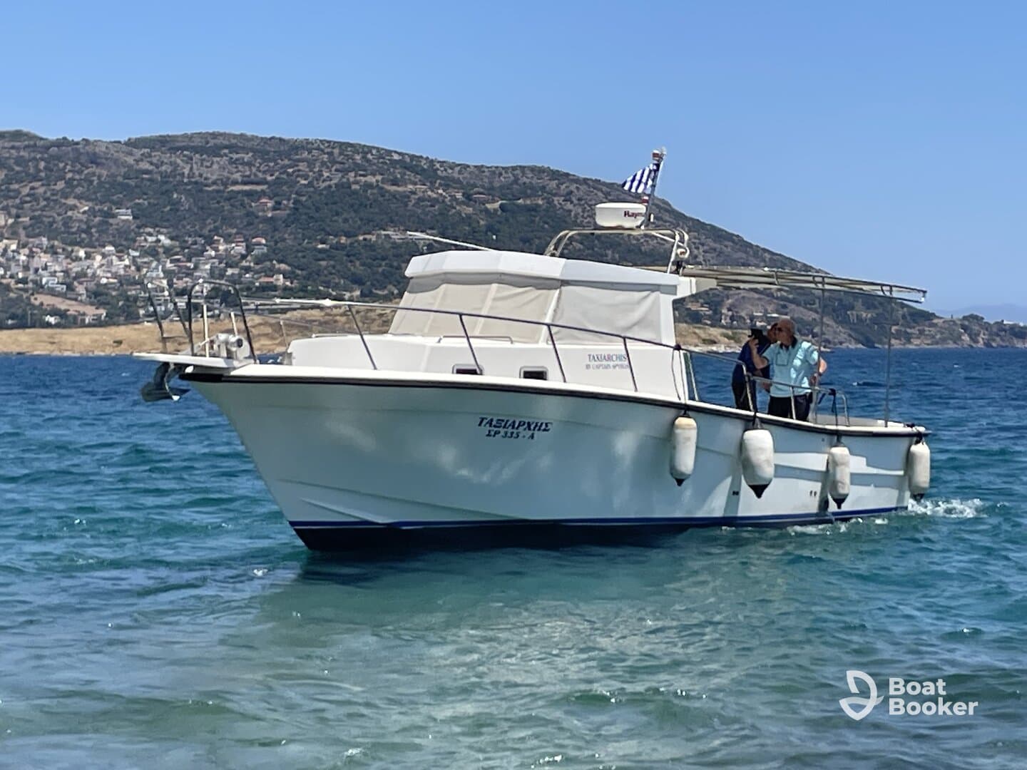 A couple enjoys a sunny day aboard a boat, surrounded by clear waters and scenic hills — perfect for a relaxing day on the sea.