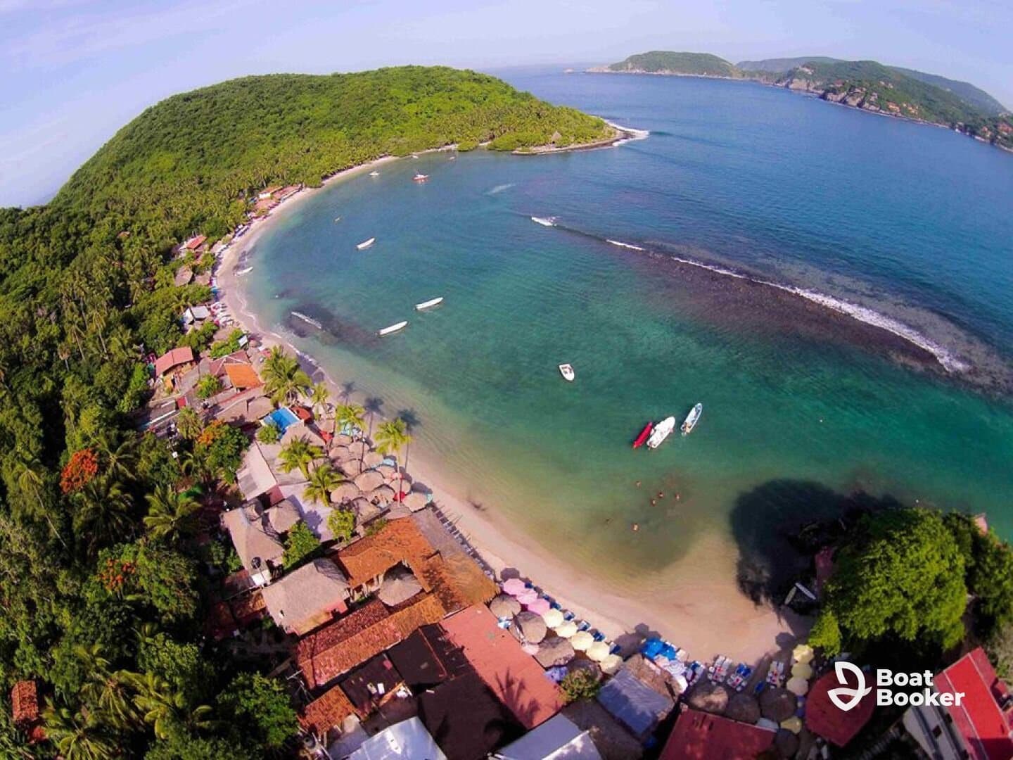 A stunning aerial view of a picturesque beach with boats anchored in the clear waters, showcasing the vibrant coastline and lush greenery — an ideal destination for relaxation and water activities.