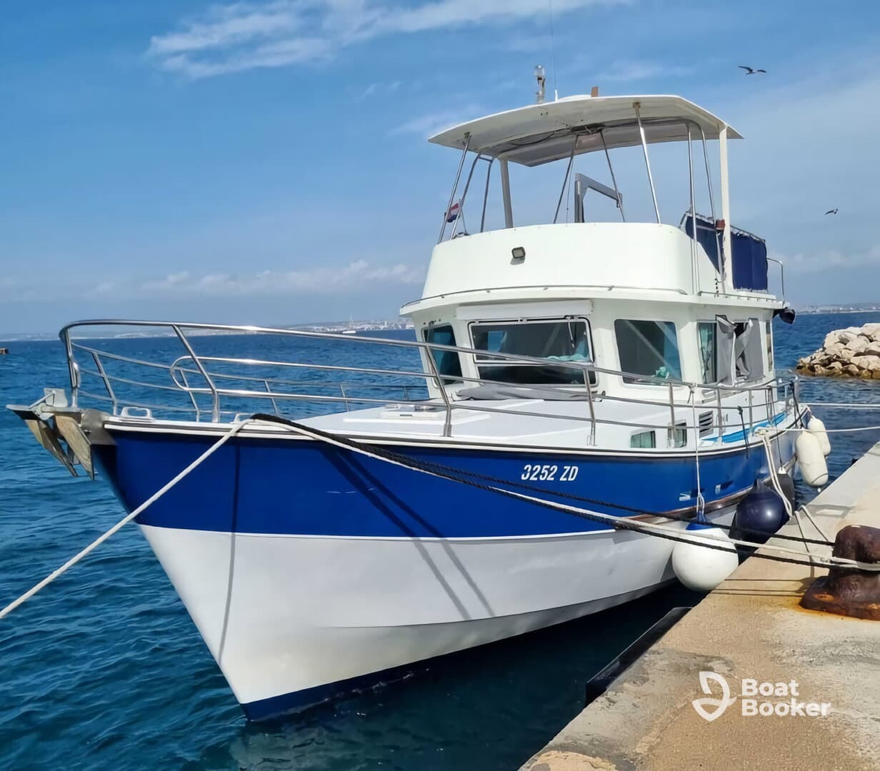 A well-maintained boat docked at the harbor, showcasing its sleek design and vibrant colors against the clear blue water.