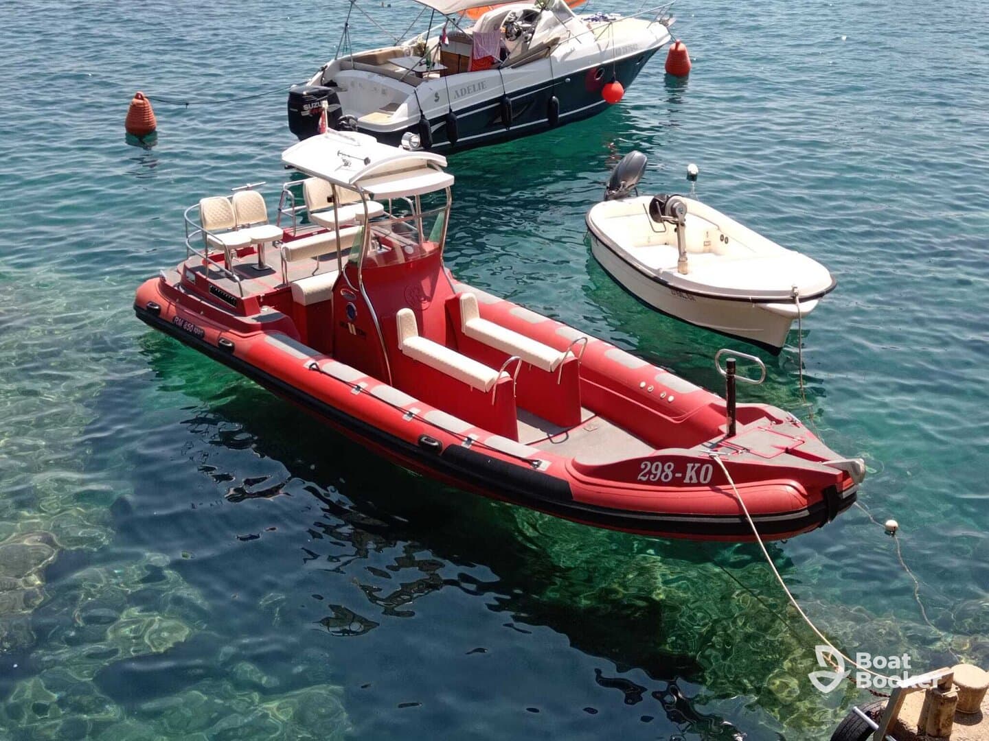 A vibrant red speedboat docked in clear turquoise waters, showcasing its sleek design and inviting seating — perfect for a day on the water.