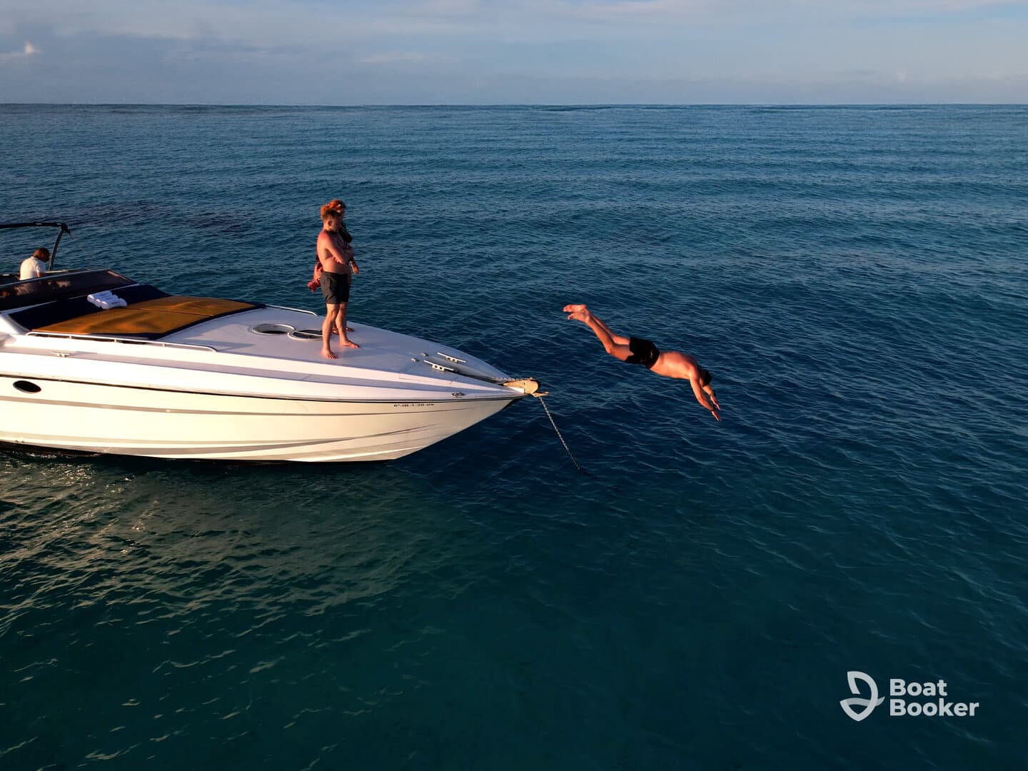A thrilling moment captured as a person dives off the bow of a boat into the clear blue waters, showcasing the excitement of summer adventures on the water.