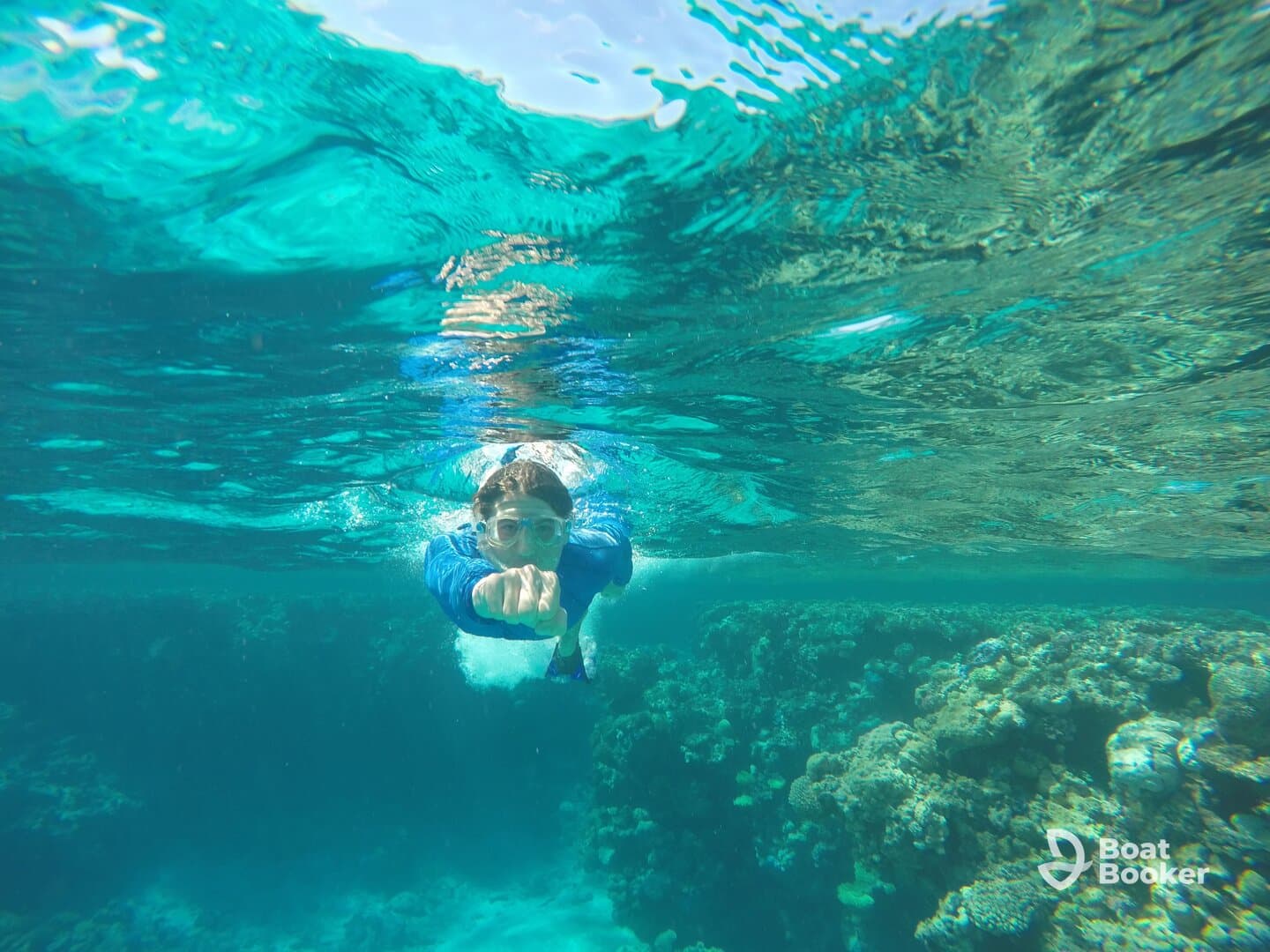 A young swimmer explores vibrant coral reefs while snorkeling in crystal-clear waters, showcasing the beauty of underwater adventures.