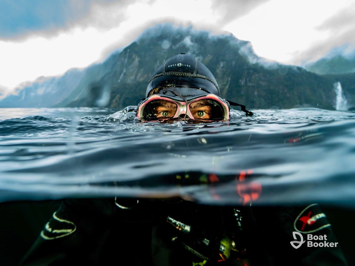 A diver emerges from the water, showcasing the stunning mountainous backdrop — an exhilarating experience for adventure seekers in breathtaking locations.