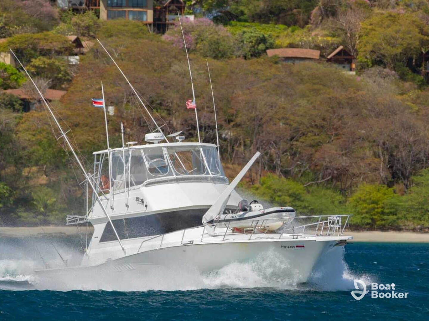 A sleek speedboat cuts through the water, showcasing its impressive design and performance against a lush green backdrop.