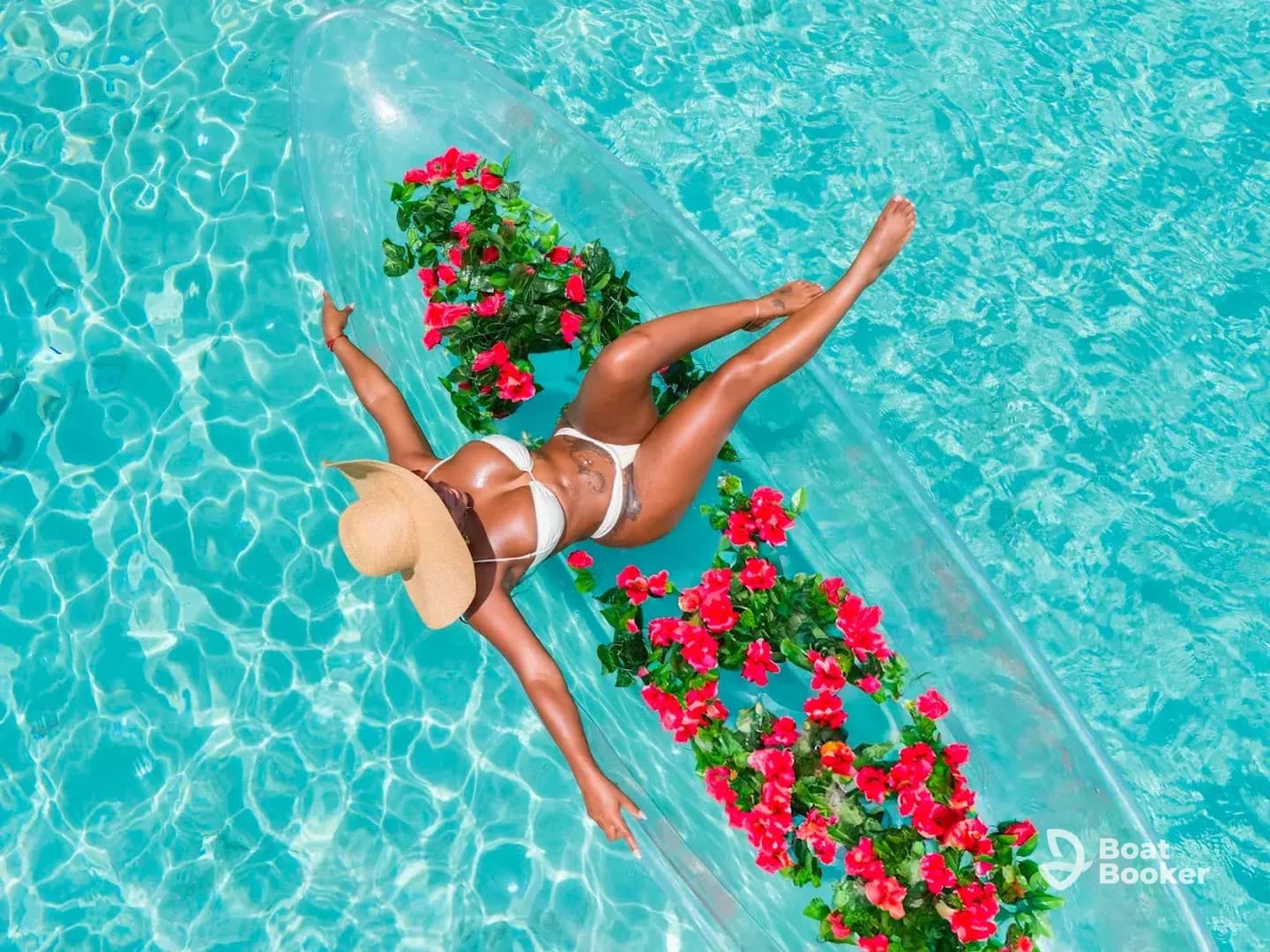 A woman relaxes on a floral-decorated float in a sparkling pool, embodying the essence of summer leisure and fun.