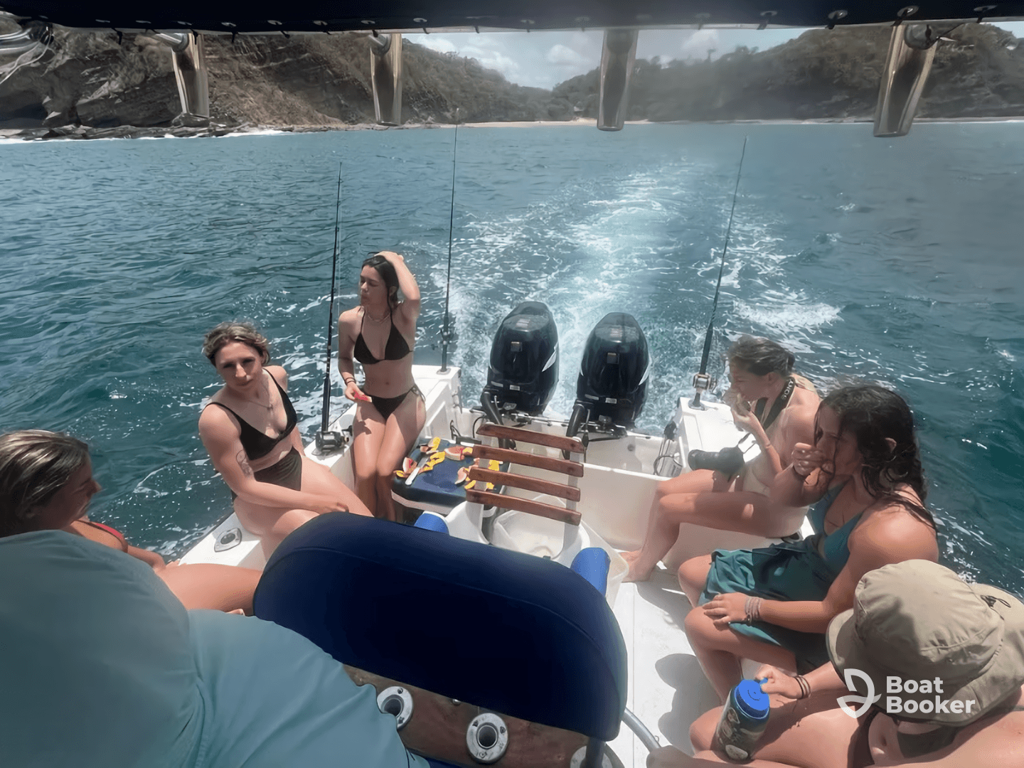 A lively group of friends enjoys their time aboard a boat, sharing snacks and laughter while surrounded by beautiful waters — perfect for a day of fun on the sea.