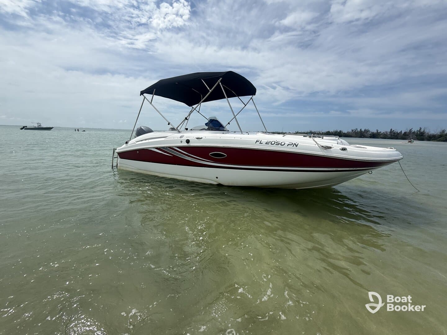 A sleek speedboat anchored in shallow waters, showcasing its stylish design against a serene backdrop — perfect for day trips and water adventures.