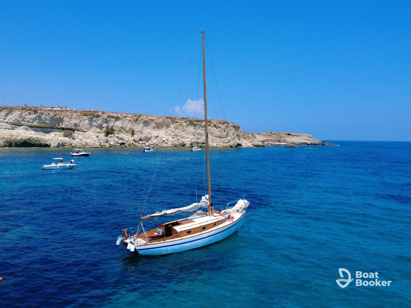 A picturesque sailboat anchored in clear blue waters, showcasing the beauty of a coastal landscape.