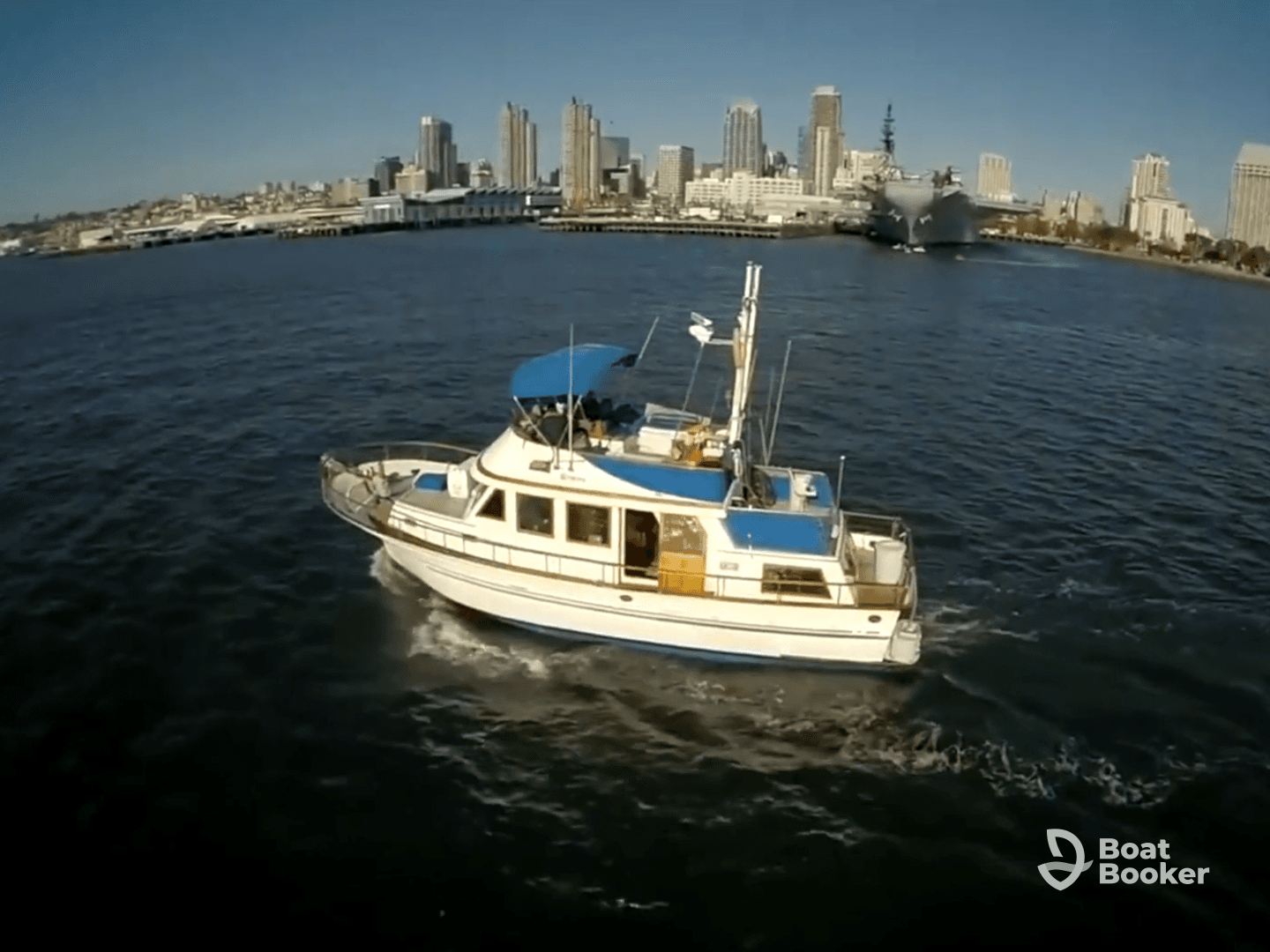 Aerial view of a yacht cruising through the waters with a stunning city skyline in the background, perfect for scenic boat tours.