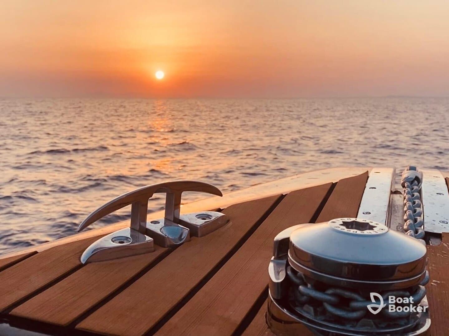 A serene sunset view from the deck of a boat, showcasing elegant wooden details and metal fixtures — perfect for capturing the tranquility of a day on the water.