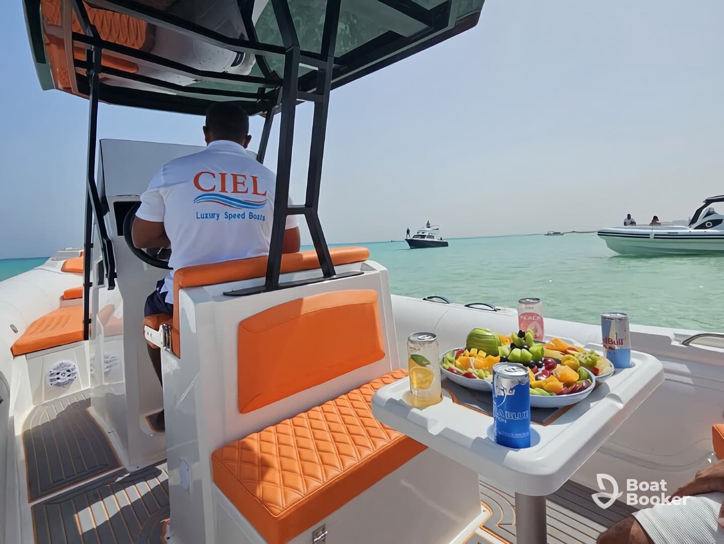 A luxurious speedboat interior featuring a well-equipped helm and a vibrant spread of fresh fruits and drinks, perfect for a day on the water.