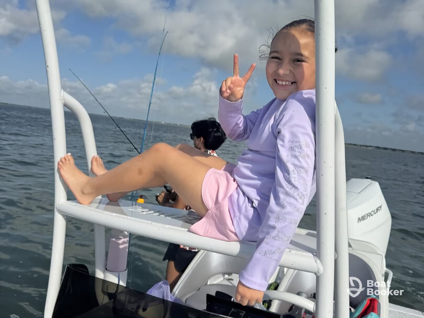 A joyful child poses with a peace sign while enjoying a fishing trip on a boat, capturing the essence of family fun on the water.