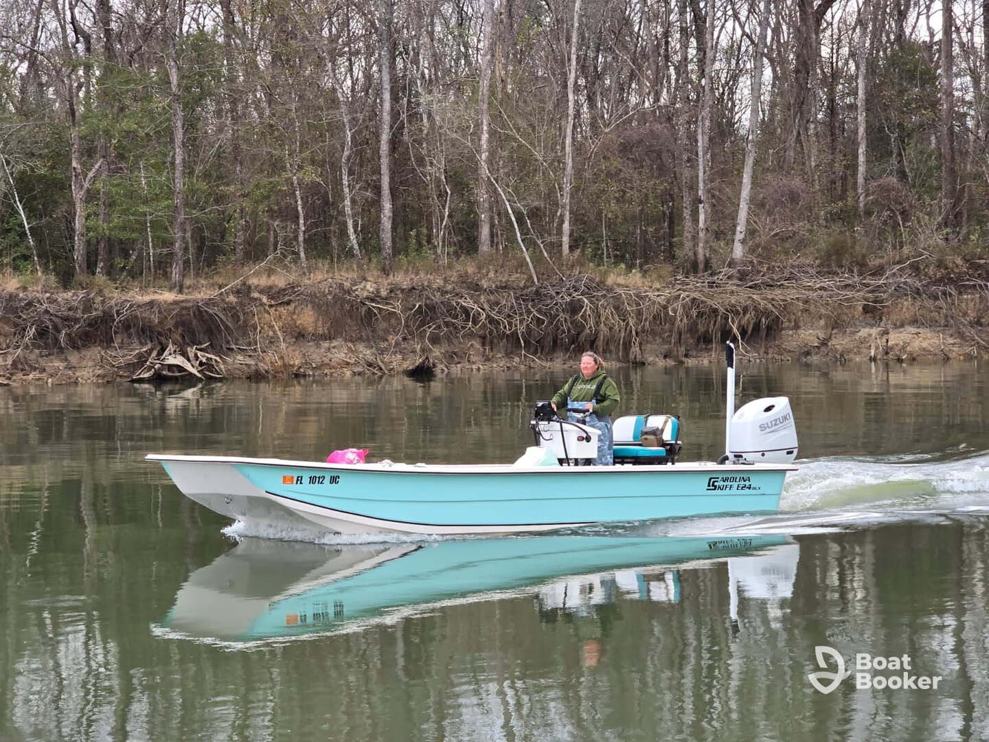 A person navigates a small fishing boat along a serene river, showcasing the tranquility of outdoor boating adventures.