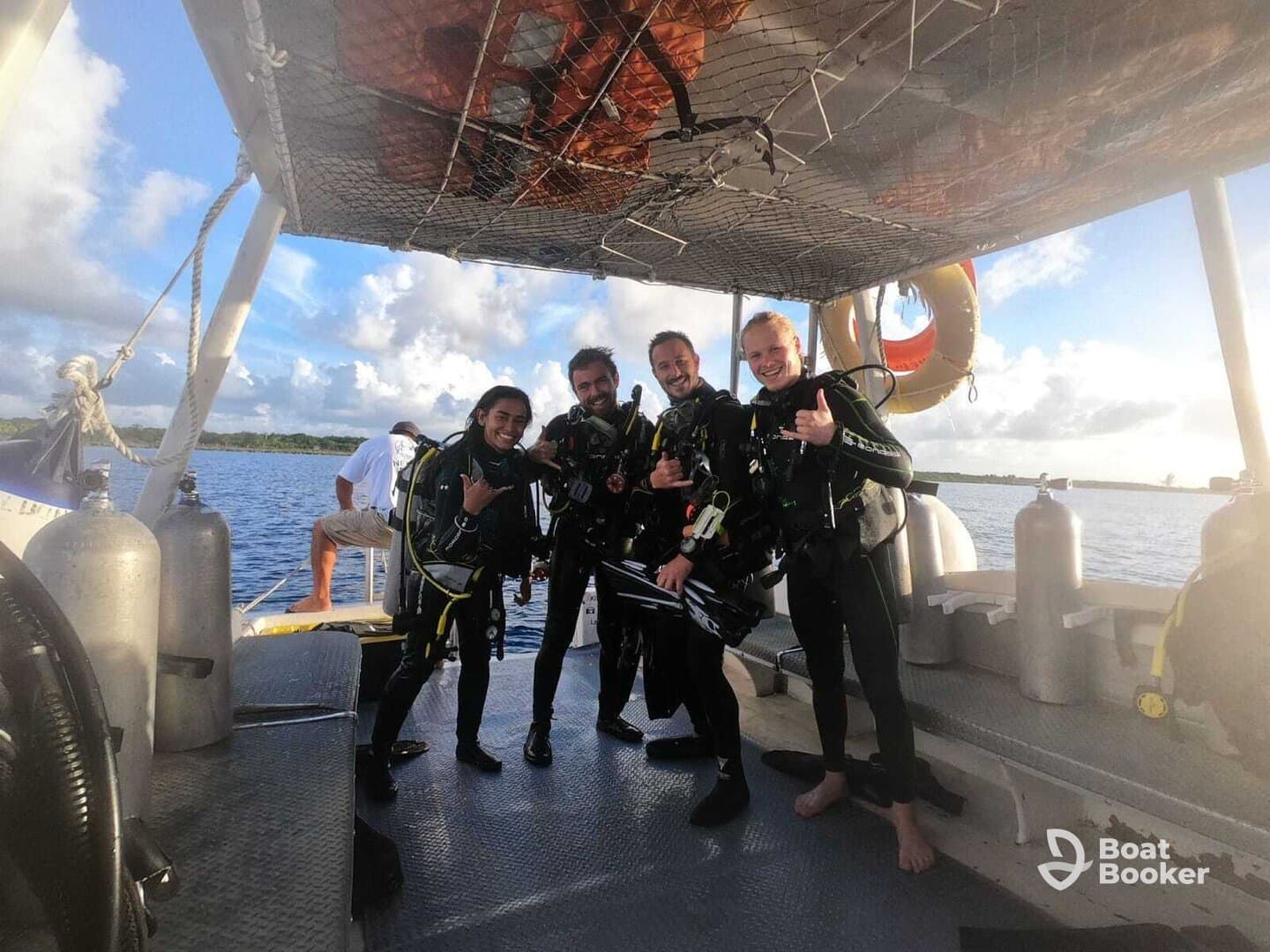 A group of divers poses on the deck of a boat, ready for an exciting underwater adventure. Perfect for showcasing the thrill of scuba diving and group experiences on the water.