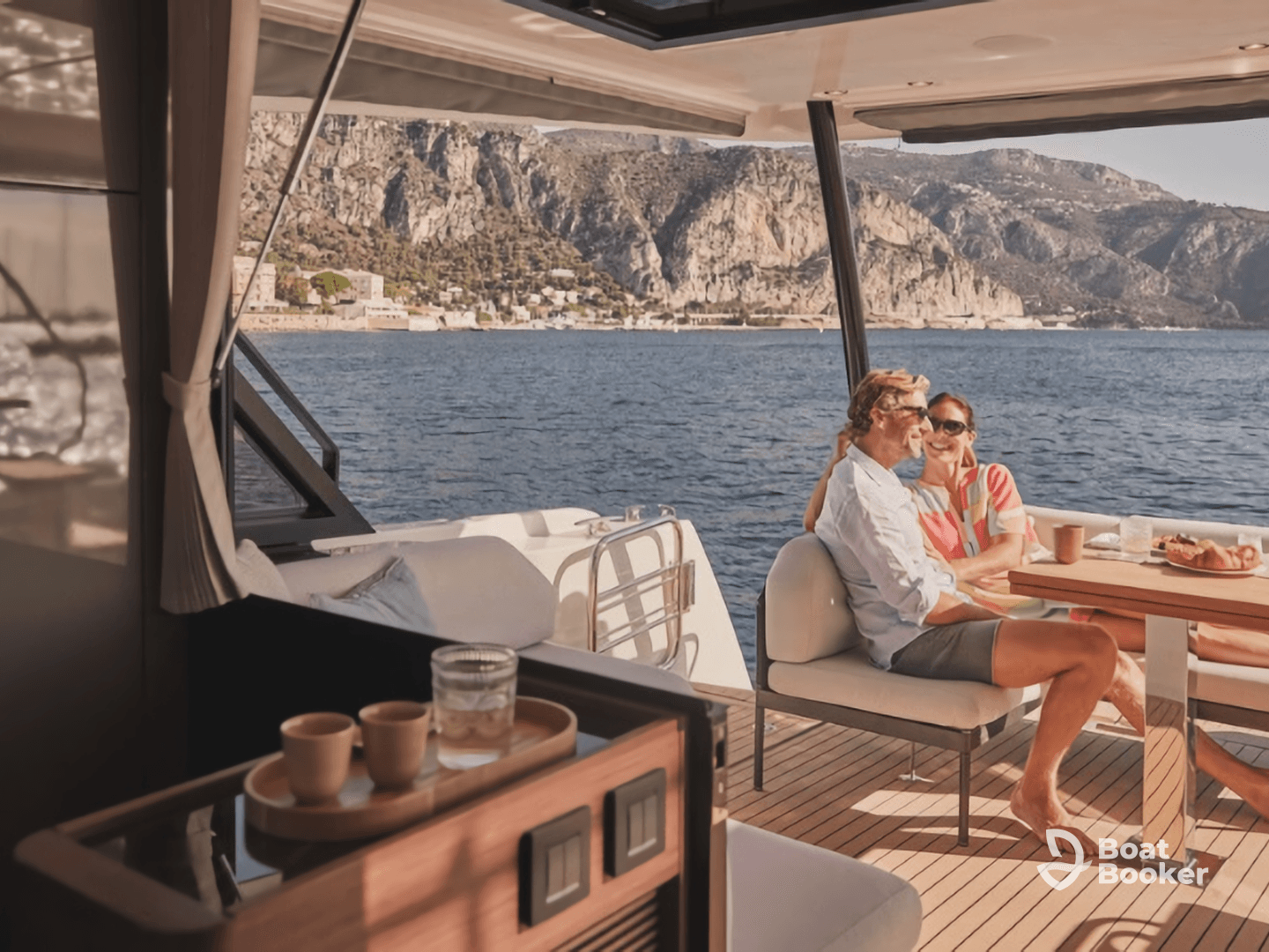 A couple enjoys a delightful meal on the deck of a yacht, surrounded by stunning coastal scenery — perfect for romantic getaways or special celebrations on the water.