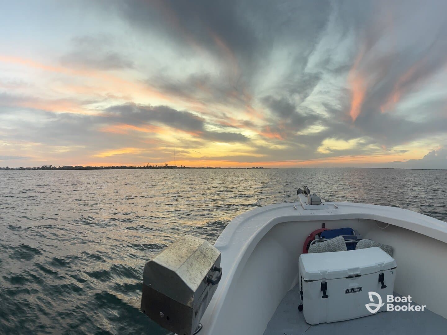 A serene view from the bow of a boat at sunset, showcasing the tranquil waters and vibrant sky — perfect for evening cruises.