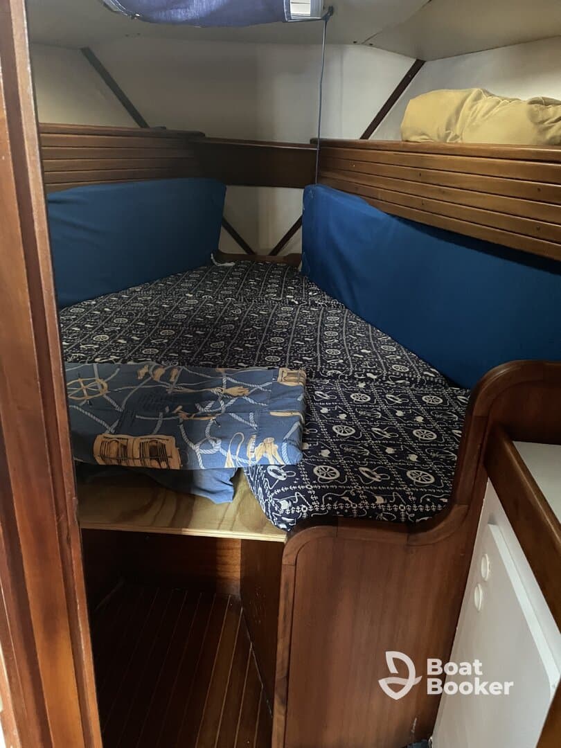 Cozy interior cabin space featuring comfortable seating and a nautical-themed mattress, perfect for relaxing on a boat.