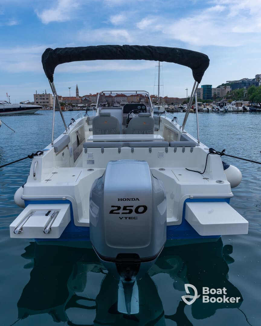 A sleek speedboat docked in calm waters, showcasing its powerful Honda 250 VTEC engine — perfect for thrilling adventures on the water.