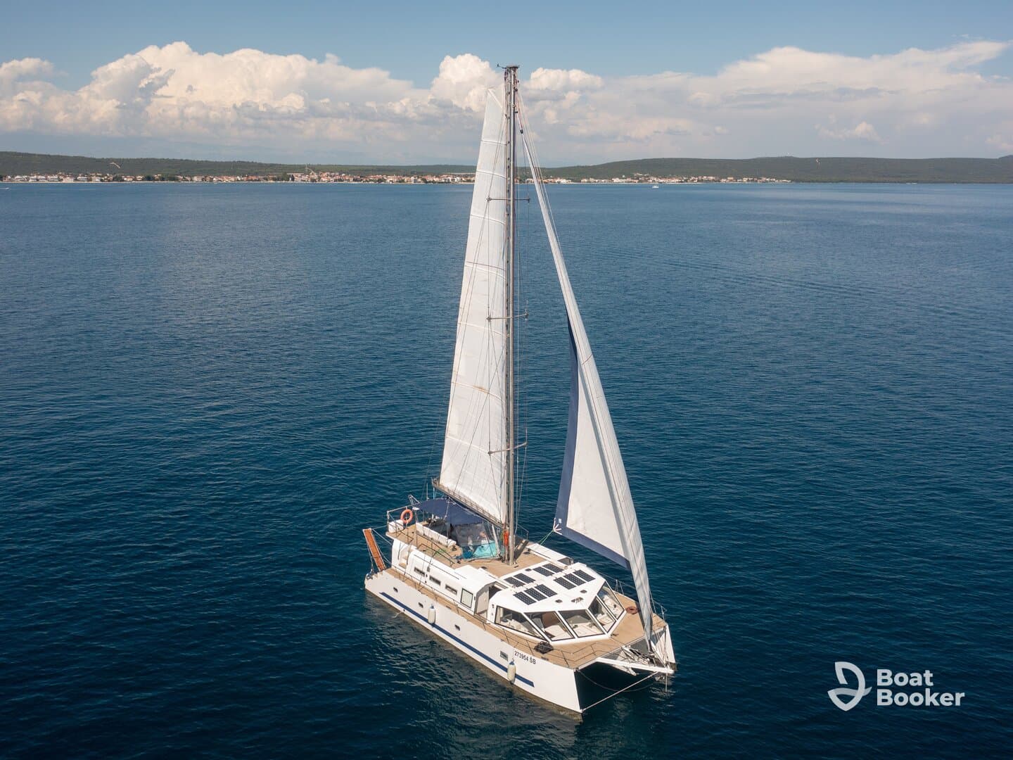 A stunning aerial view of a catamaran sailing through calm waters, showcasing its elegant design and spacious deck — perfect for leisurely cruises or island hopping adventures.
