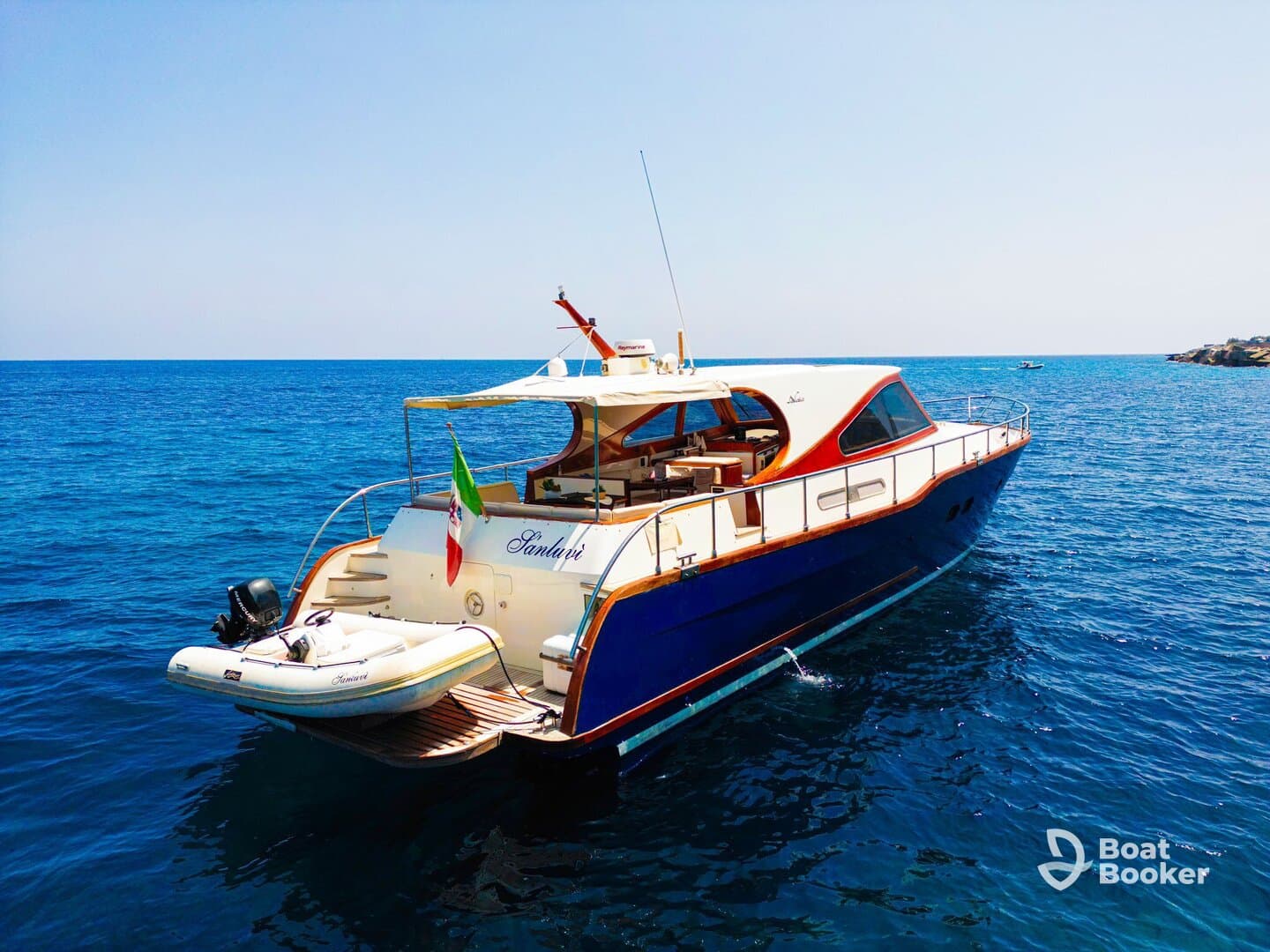 A stunning yacht named 'Sanduri' anchored in crystal-clear waters, showcasing its elegant design and vibrant colors — perfect for luxury boating experiences.