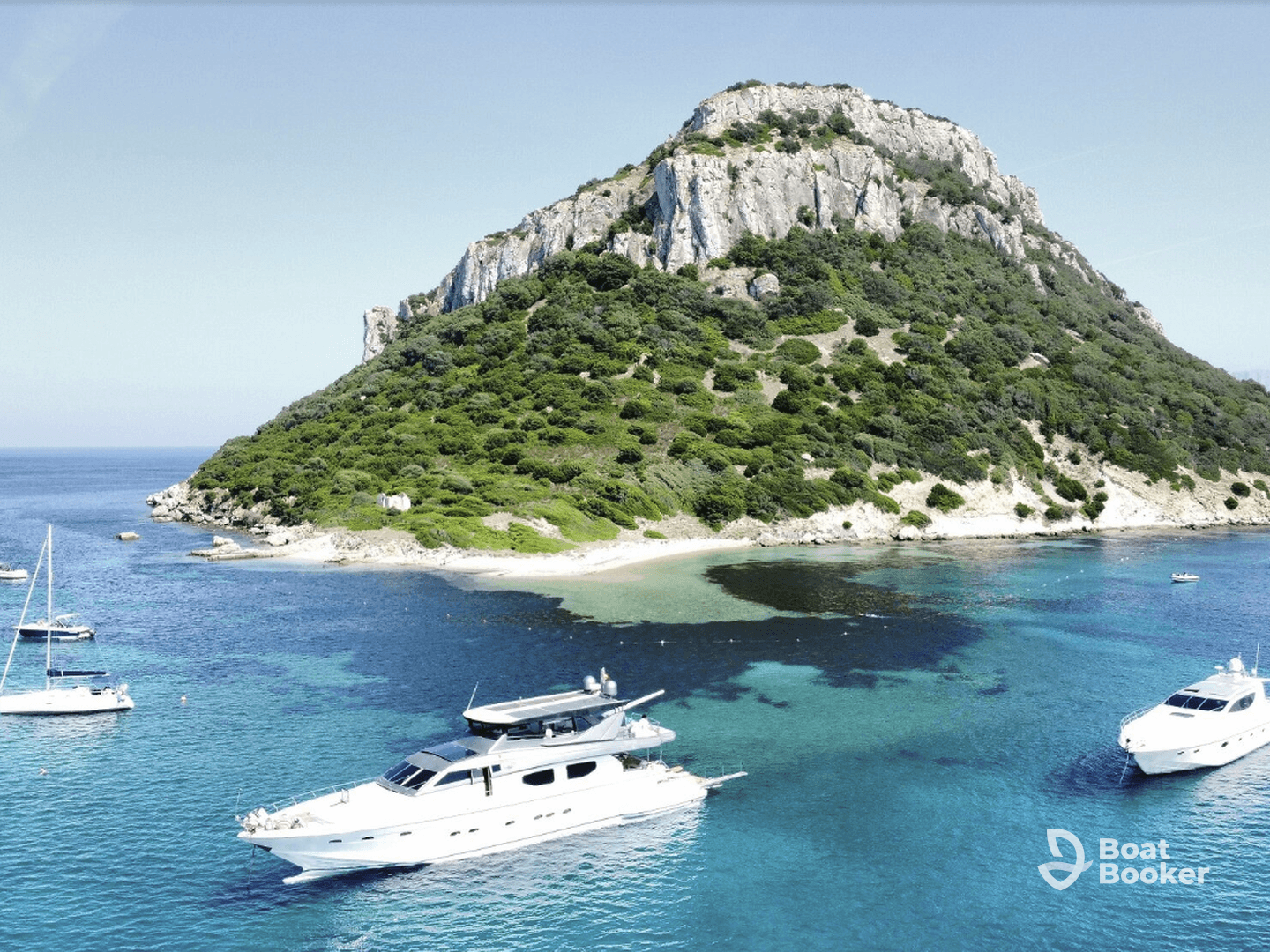 A stunning aerial view of a luxurious yacht navigating through crystal-clear waters, with a picturesque rocky island in the background — ideal for showcasing boating adventures.