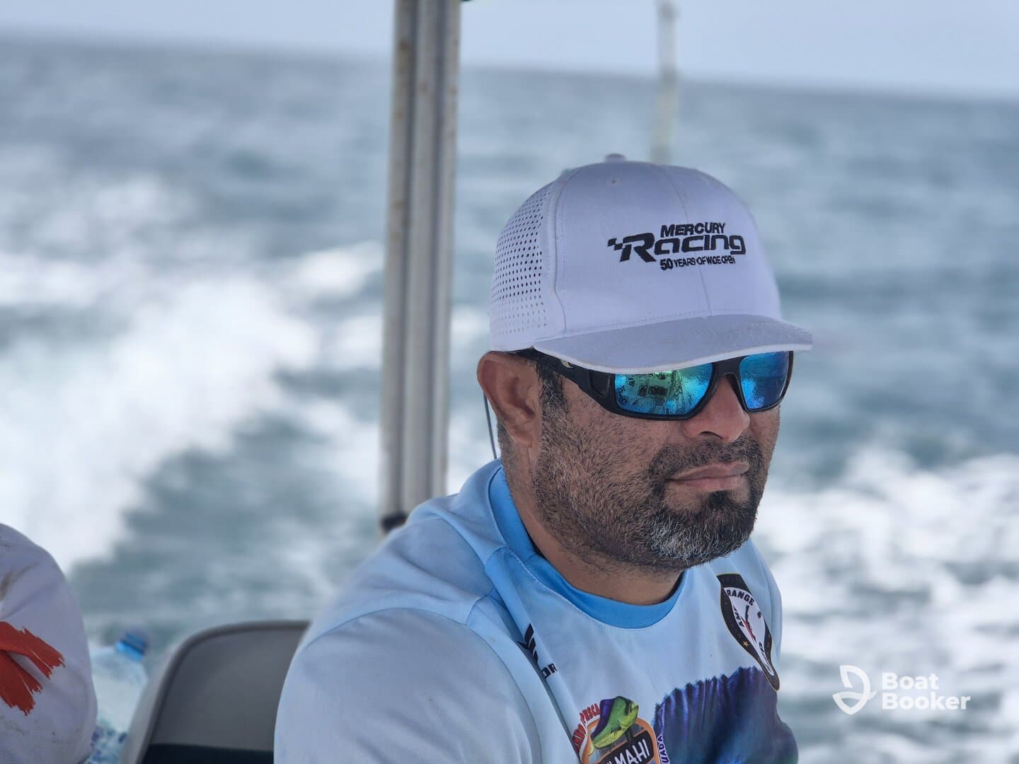 A focused individual on a boat, enjoying the ocean view while navigating the waters. Perfect for showcasing the boating experience.