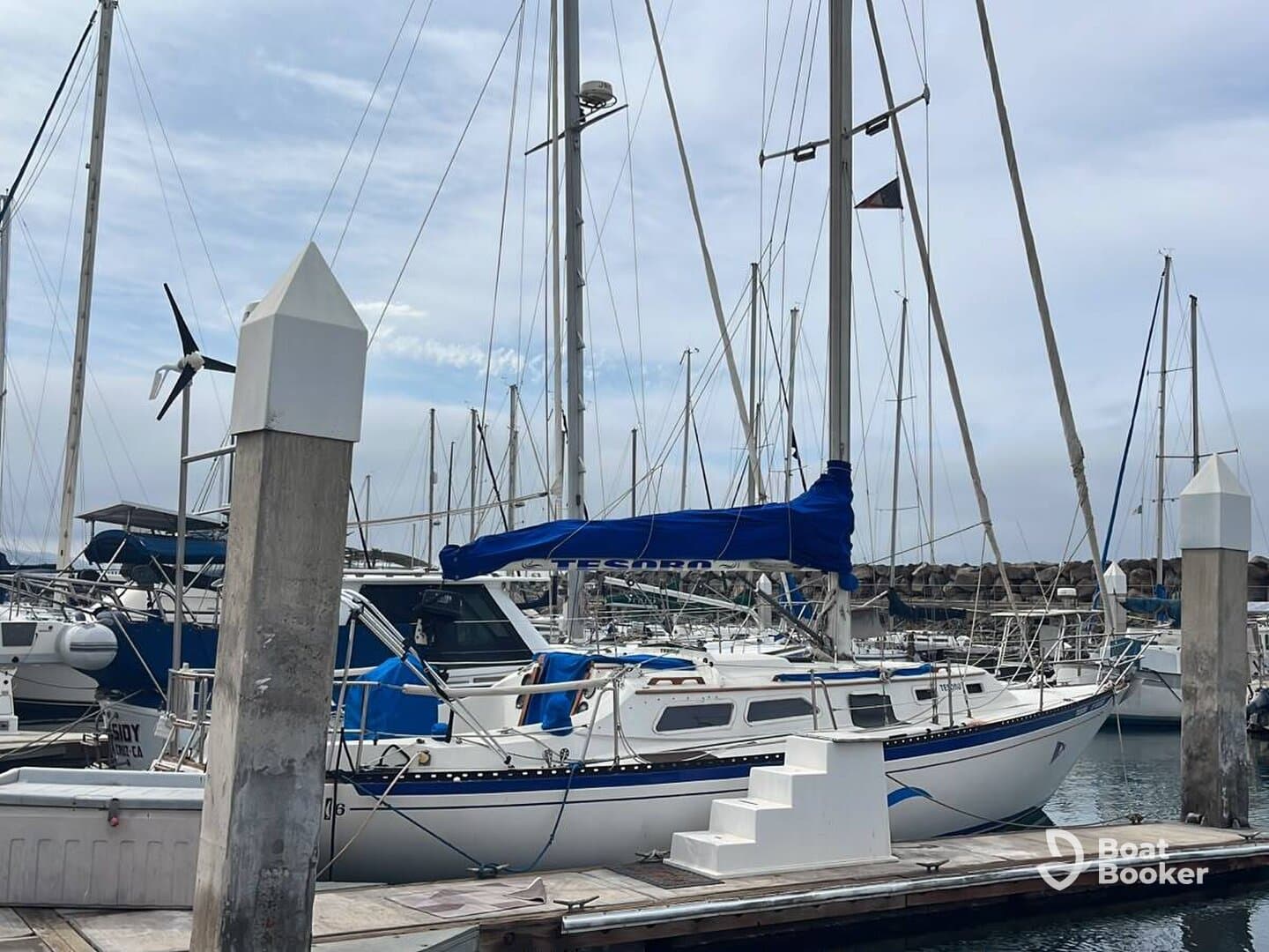 A beautiful yacht docked at the marina, showcasing its sleek design and vibrant blue accents, perfect for sailing enthusiasts.
