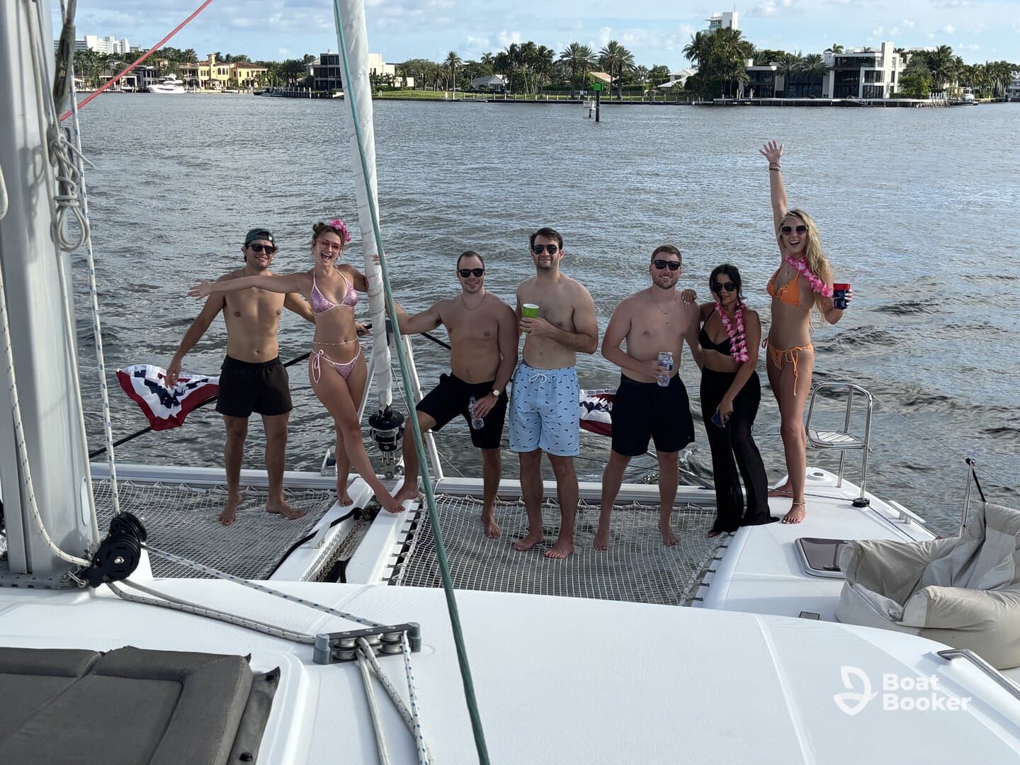A lively group of friends celebrates aboard a catamaran, enjoying drinks and the sun — perfect for a fun day on the water.