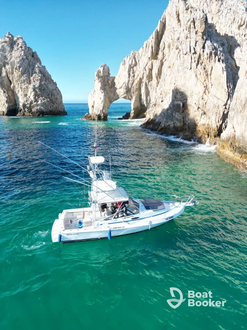 A fishing boat navigates the stunning waters near iconic rock formations, showcasing the beauty of the coastline — perfect for adventure seekers and nature lovers.