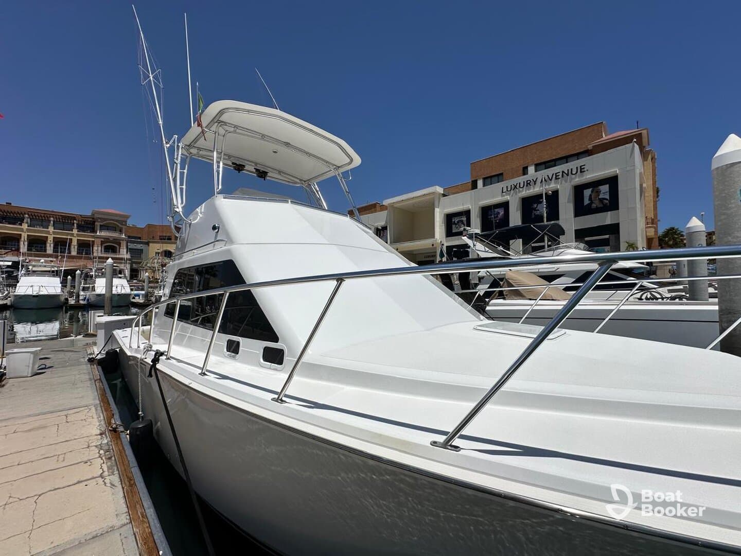A sleek yacht docked at the marina, showcasing its elegant design against a clear blue sky — perfect for luxury outings and charters.