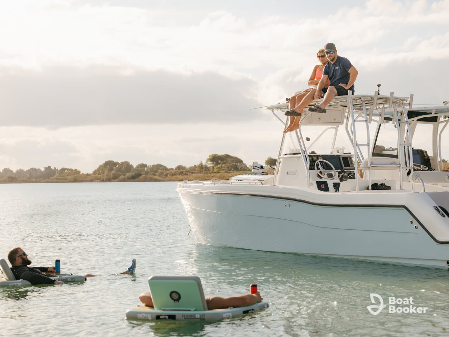 A group enjoys a relaxing day on the water, with some floating nearby while others sit on the boat, showcasing the perfect blend of leisure and fun.