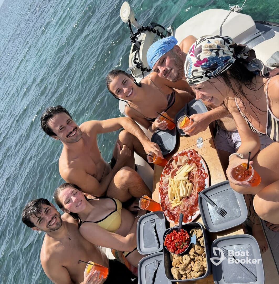 A lively group enjoys a fun day on the water, sharing delicious snacks and cocktails aboard a boat — perfect for summer celebrations and gatherings.