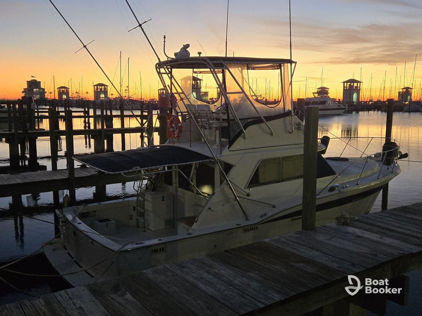 A serene view of a yacht docked at sunset, reflecting the warm colors of the sky — perfect for evening cruises or relaxing at the marina.