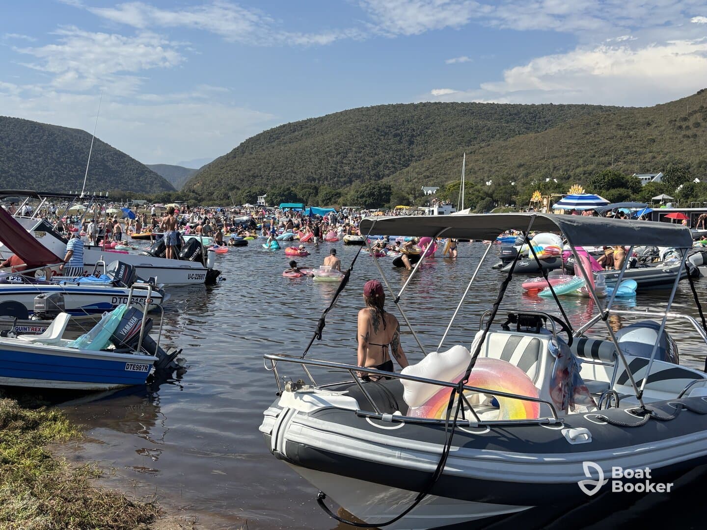 A vibrant scene of people enjoying a lively day on the water, surrounded by boats and colorful floaties, perfect for summer fun and social gatherings.