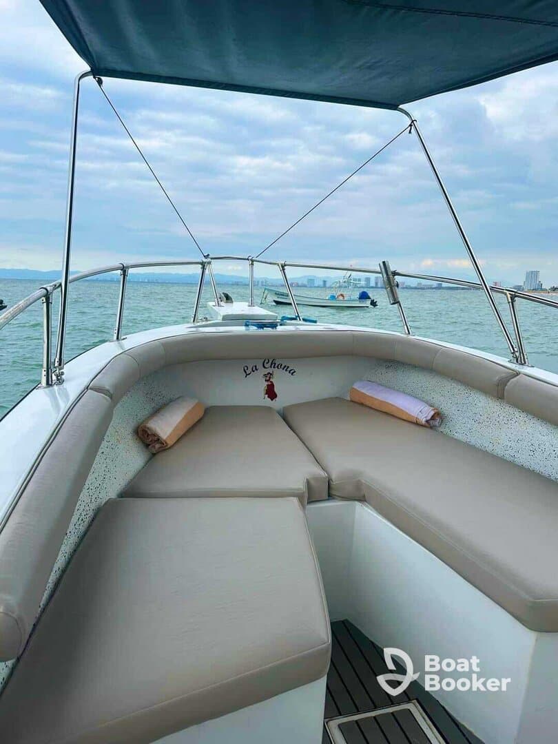 A cozy interior view of a boat's seating area, featuring comfortable cushions and a serene backdrop of the water, perfect for relaxing during a day on the sea.